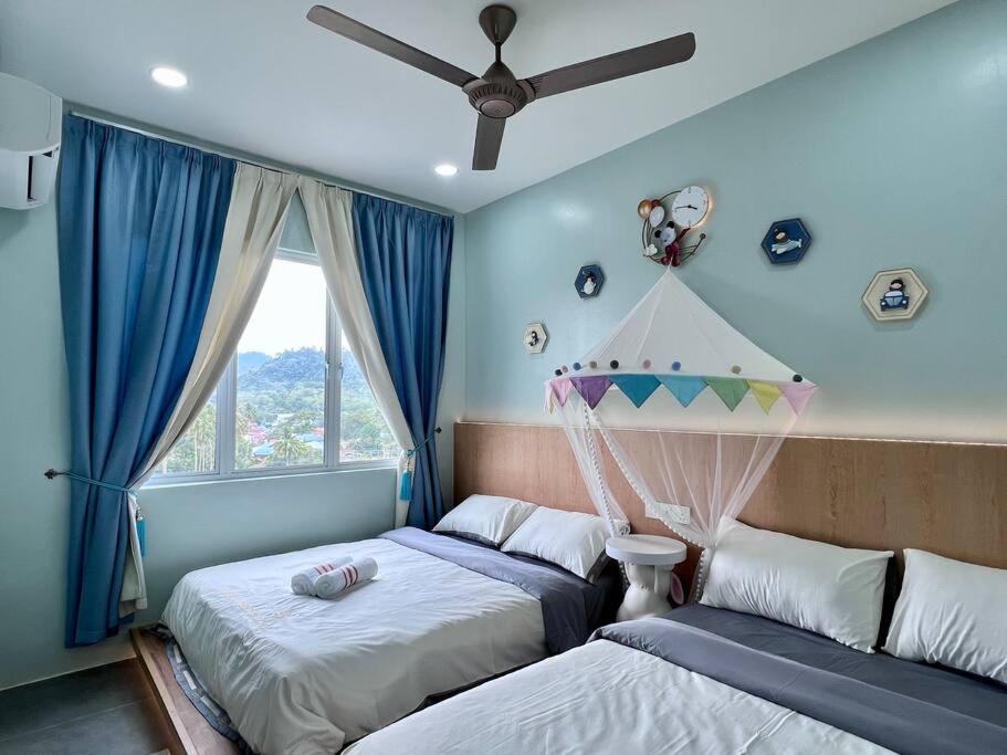 - une chambre avec 2 lits et un ventilateur de plafond dans l'établissement Mountain View 604, à Kuah