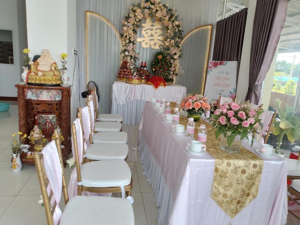 Ấp Sung Xuân的住宿－Homestay Hoài Tâm Phan Thiết，一排桌椅,上面有鲜花