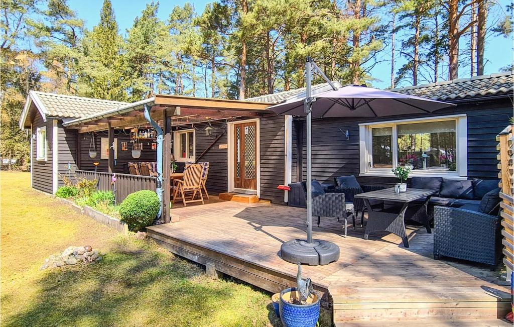 a wooden deck with a couch and an umbrella at 2 Bedroom Cozy Home In hus in Åhus