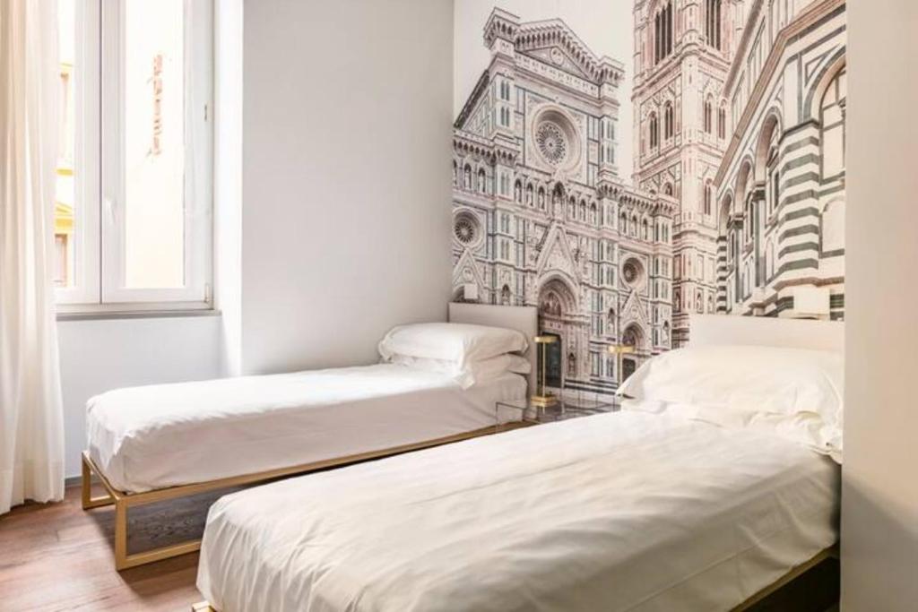2 Betten in einem Zimmer mit Wandbild in der Unterkunft ECOZYHOUSE in Florenz