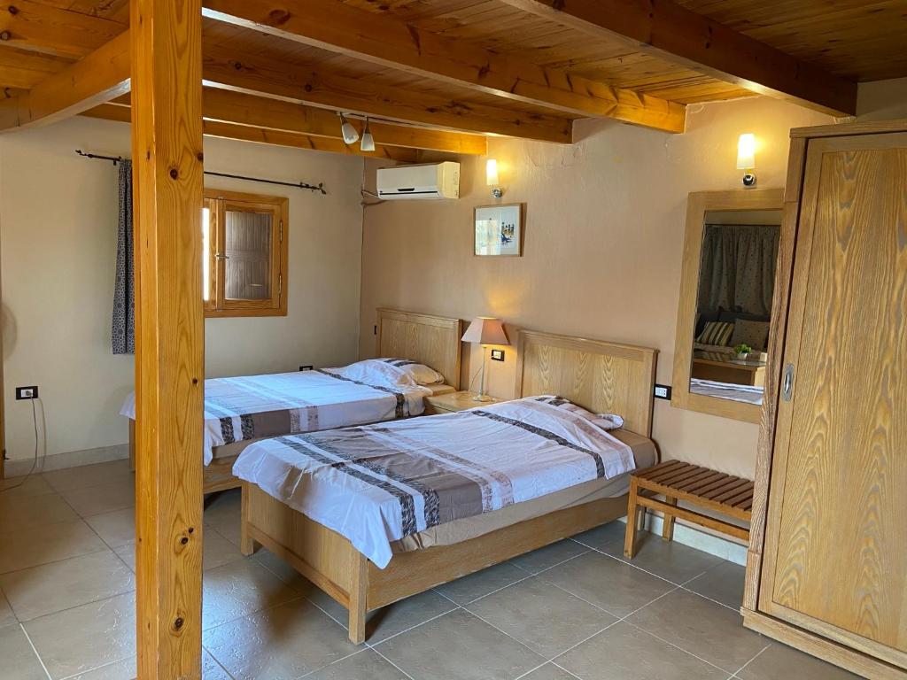 2 camas en una habitación con techos de madera en View Villa Apartments Hurghada, en Hurghada