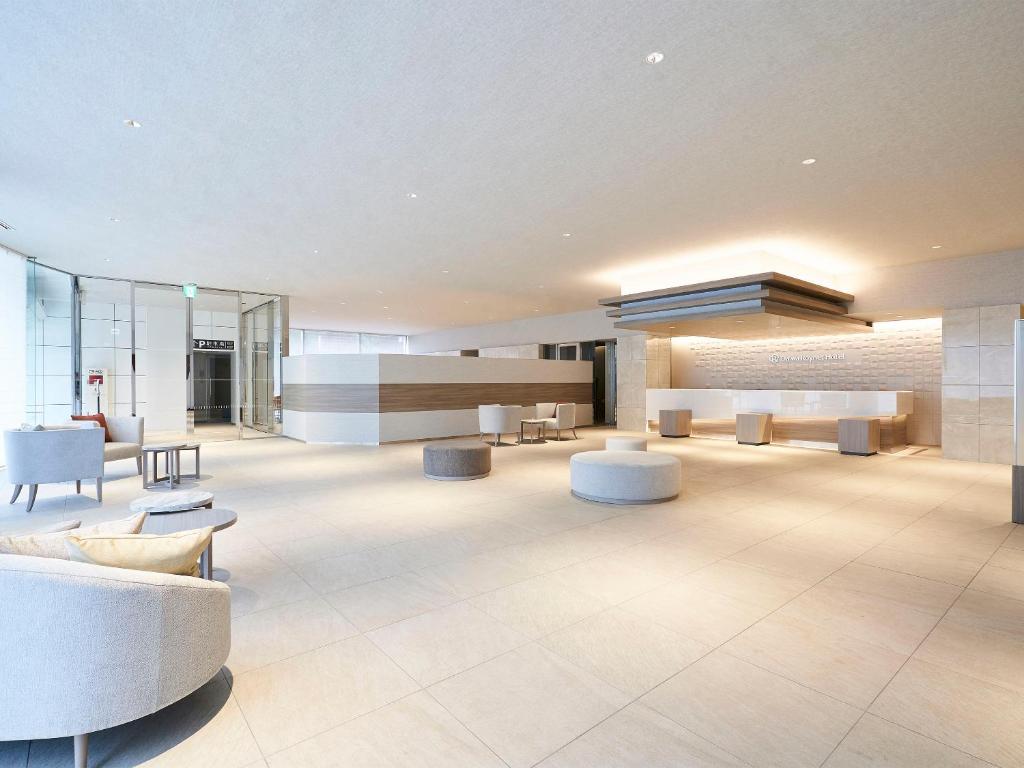 a lobby with couches and chairs in a building at Daiwa Roynet Hotel Nagoya Shinkansenguchi in Nagoya