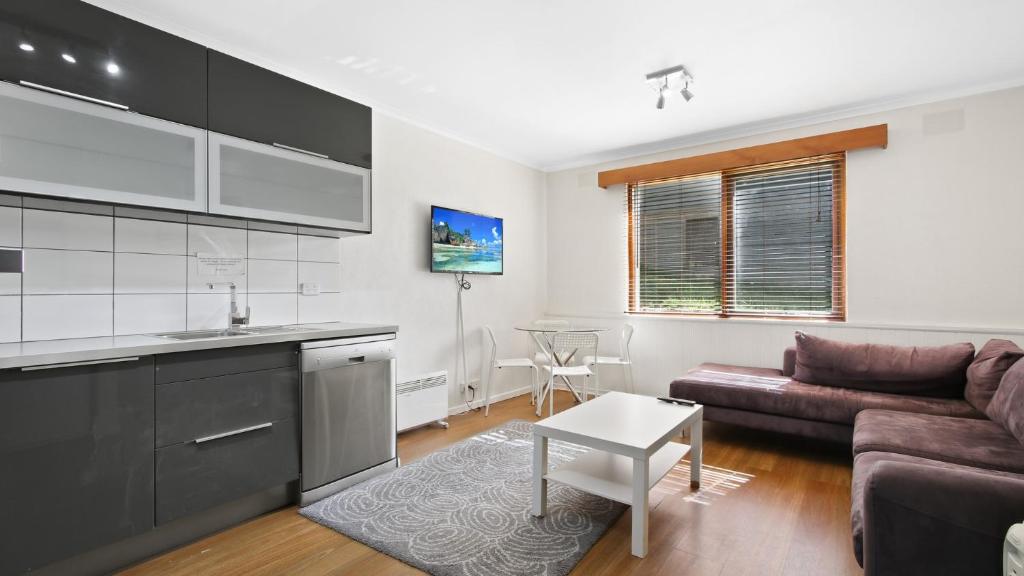a kitchen and living room with a couch and a table at Alpine Haven 5 in Mount Hotham