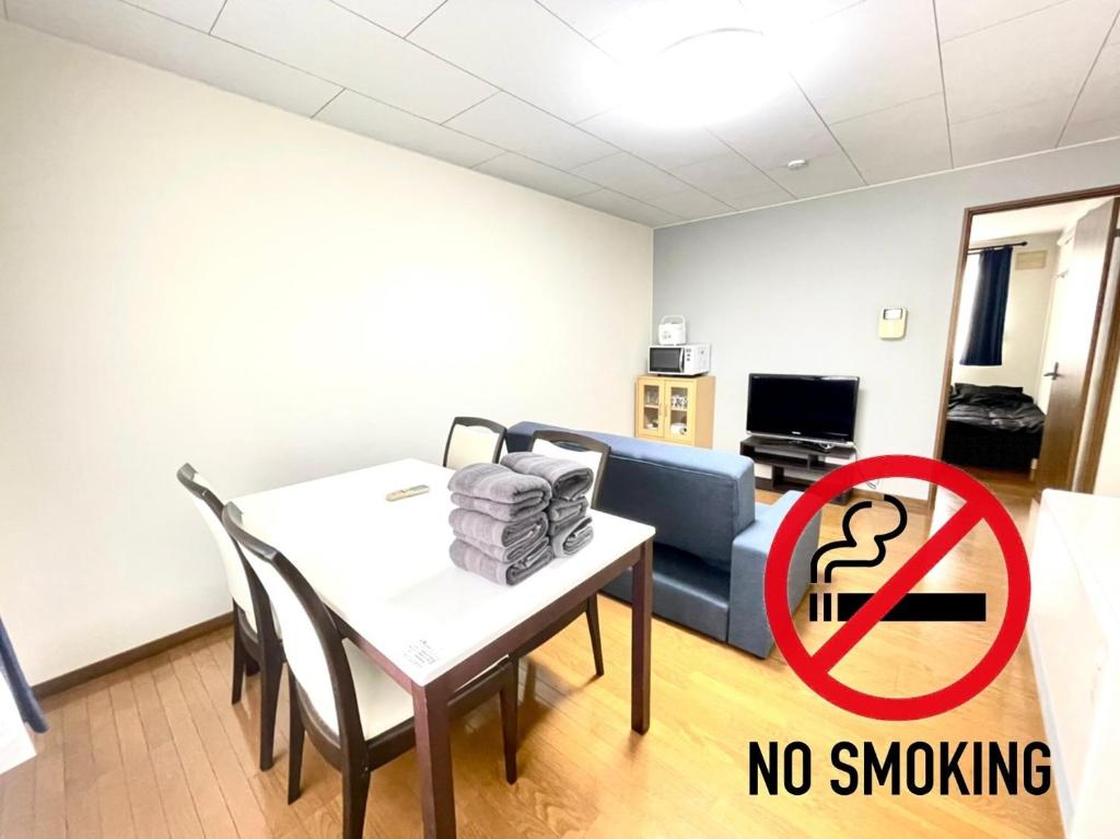 a living room with a table and a couch and a no smoking sign at Avidasion - Vacation STAY 13343 in Biei