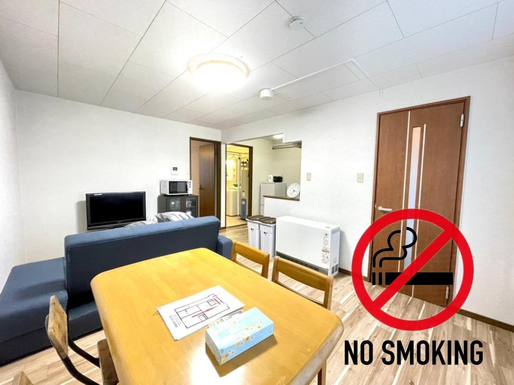 uma sala de estar com um sofá e uma mesa com um sinal para não fumadores em Avidasion - Vacation STAY 12209 em Biei