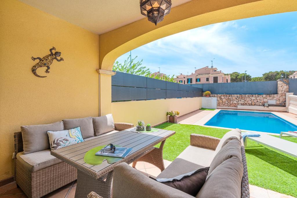 a patio with a couch and a table and a pool at Villa Alma Azul in Llucmajor