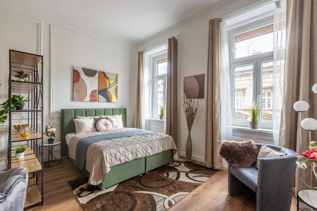 1 Schlafzimmer mit einem grünen Bett und 2 Fenstern in der Unterkunft Luxurious Art Deco Residence in the Heart of Budapest in Budapest