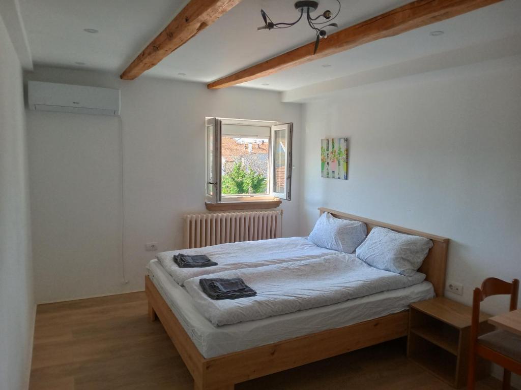 een slaapkamer met een bed in een kamer met een raam bij City Center Novi Sad in Novi Sad
