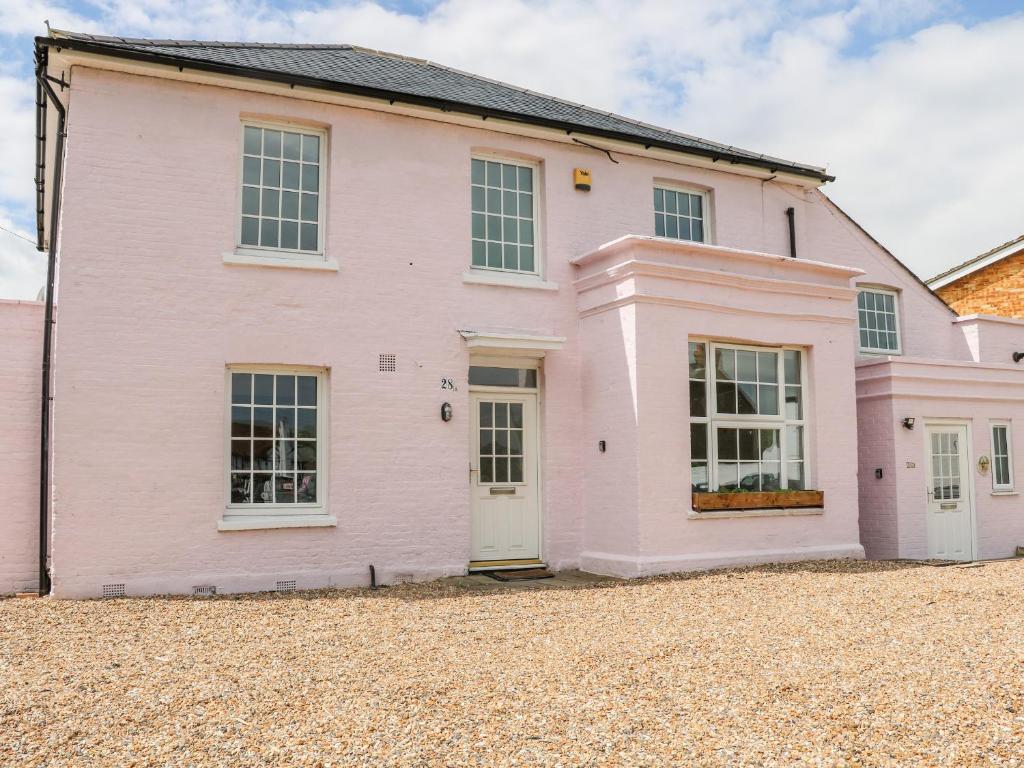 een roze huis op een grindoprit bij Burfield Cottage in Windsor