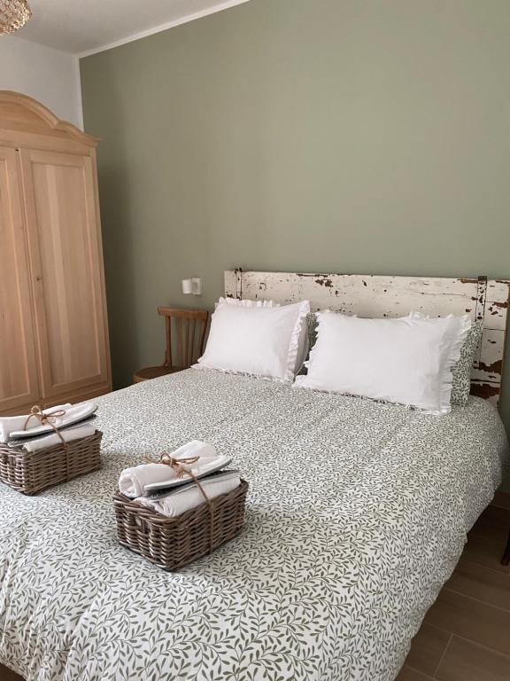 Un dormitorio con una cama con dos cestas. en B&B Antico Fienile en Gorizia