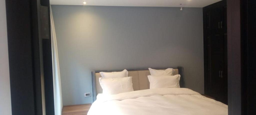 1 dormitorio con 1 cama con sábanas y almohadas blancas en Villa, en Marrakech