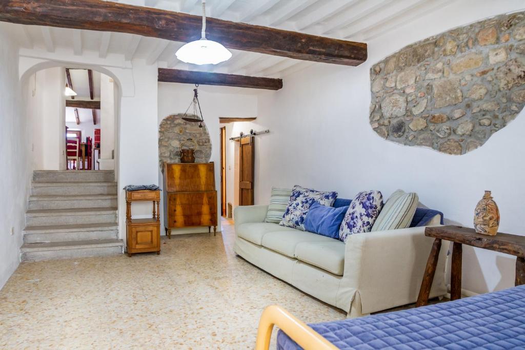 a living room with a couch and a stone wall at La casa di Maffin in Roccastrada