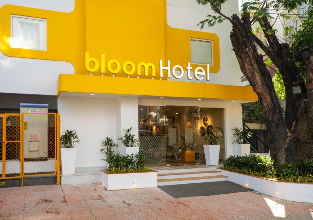 Bloom Hotel Koramangala في بانغالور: فندق اصفر وامامه شجره