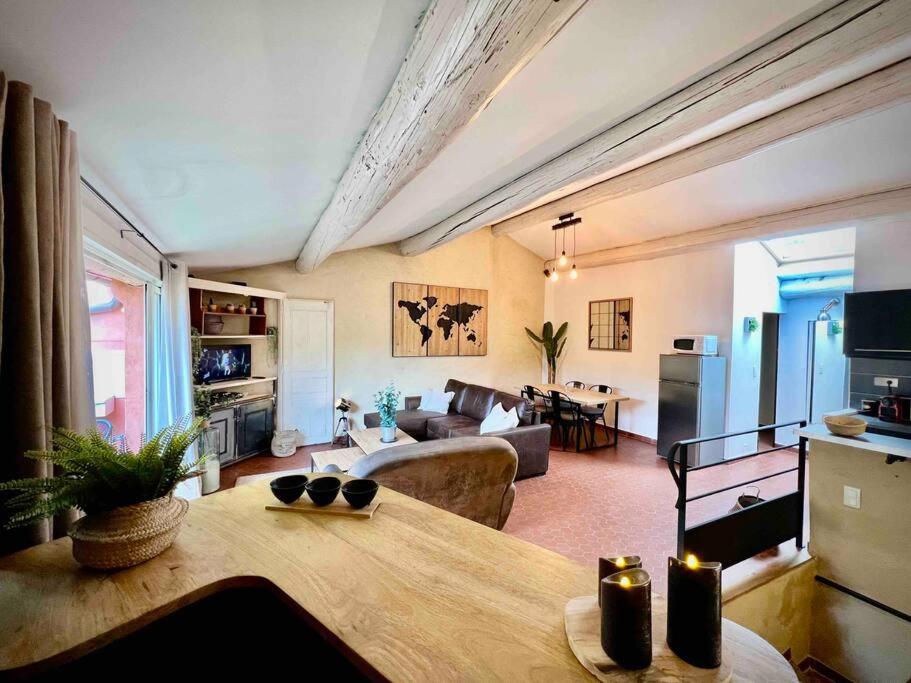 een woonkamer met een bank en een tafel bij Charmant appartement in Bédoin