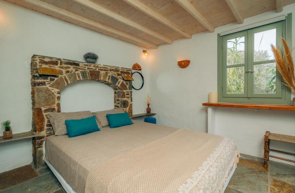 a bedroom with a bed and a stone wall at Houses at Chrisopigi Sifnos in Chrisopigi
