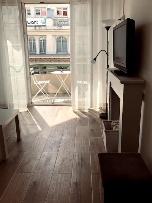 ein Wohnzimmer mit einem TV und einem großen Fenster in der Unterkunft Studio refait neuf Centre-ville in Nizza