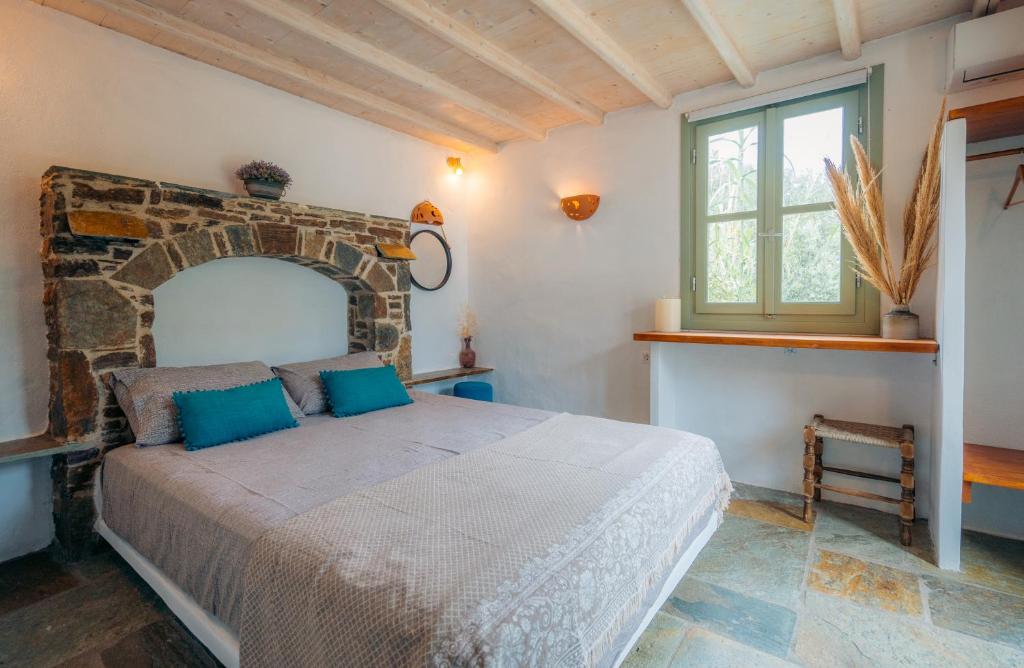 a bedroom with a bed and a window at Houses at Chrisopigi Sifnos in Chrisopigi