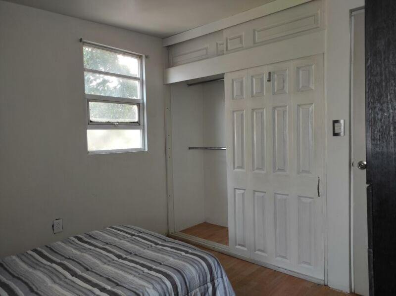 a bedroom with a bed and a door and a window at Dams house 