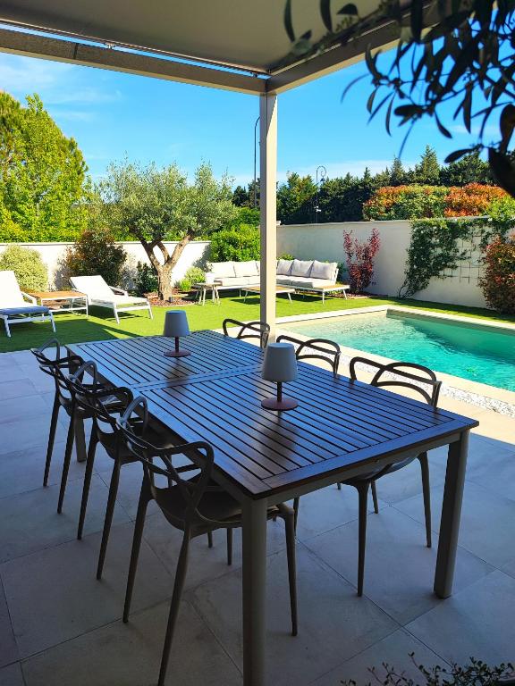 une table bleue et des chaises sur une terrasse avec piscine dans l'établissement LA FELICITA, à Pujaut