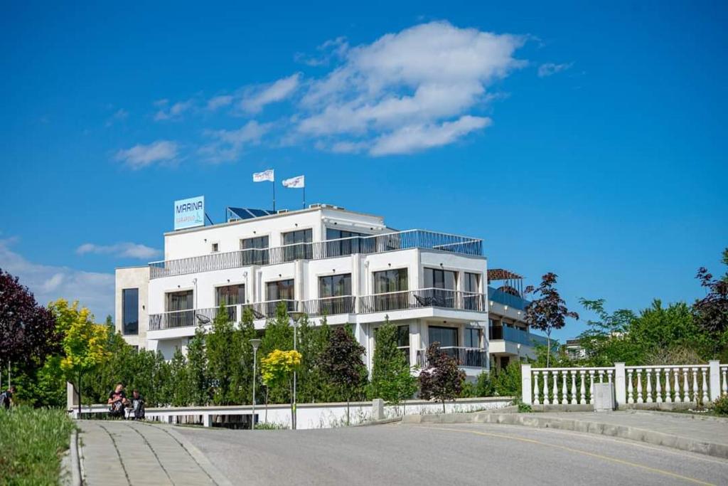 Biały budynek z dwoma flagami na górze w obiekcie Marina Sarafovo w Burgas