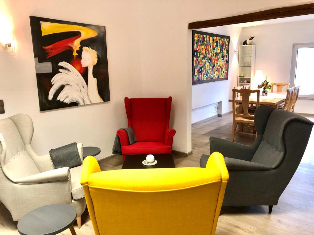 科赫姆的住宿－Am alten Apfelbaum - Fewo 2，客厅配有色彩缤纷的椅子和绘画作品