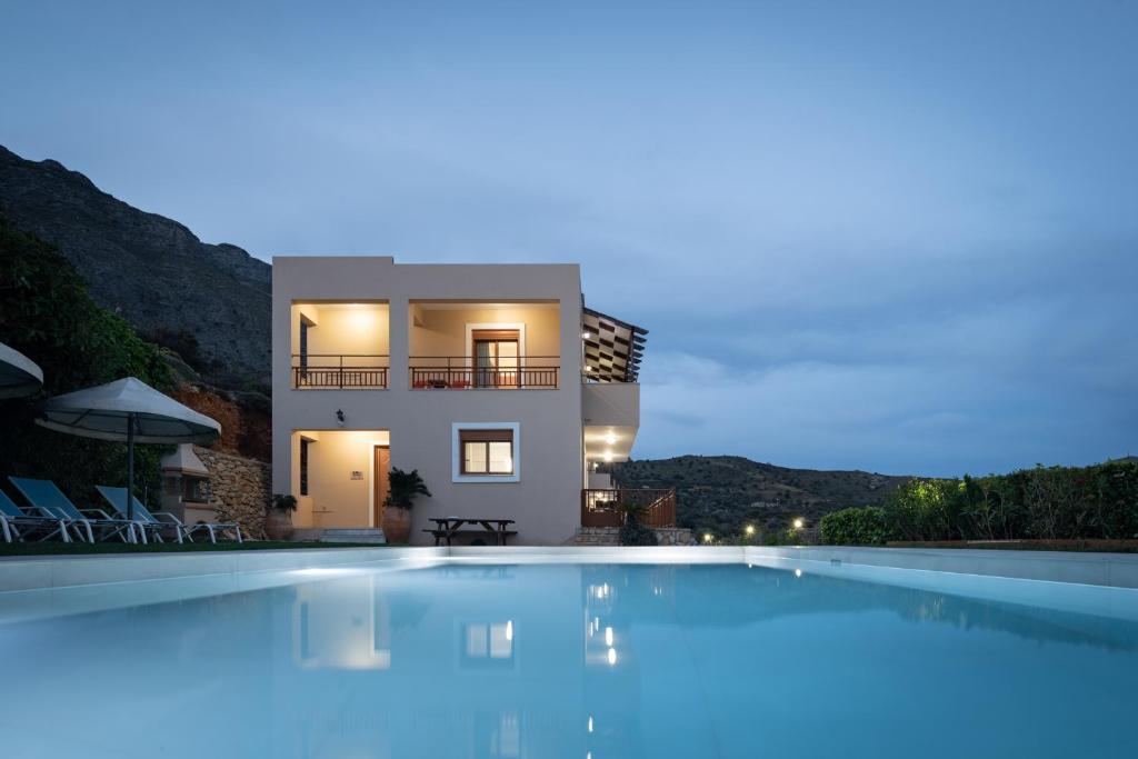 a villa with a swimming pool at night at Triopetra Luxury Villas Panagia in Triopetra