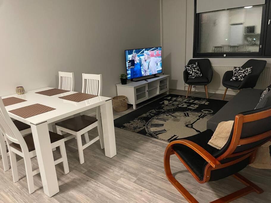 uma sala de estar com uma mesa e cadeiras e uma televisão em 2BR with sauna in Tornio city em Tornio