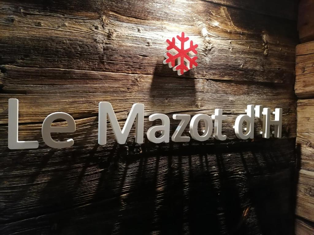een bord op een houten muur met het woord maccot olie bij Le mazot d'H in Entremont