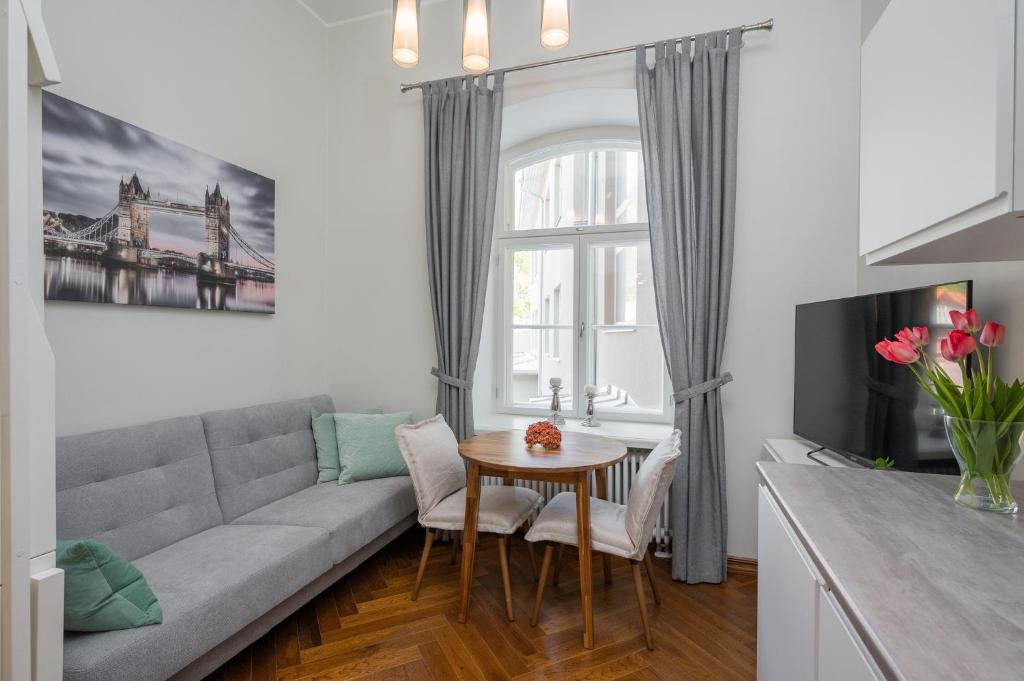 ein Wohnzimmer mit einem Sofa und einem Tisch in der Unterkunft Grand Hotell Residents loft Tartu vanalinnas in Tartu
