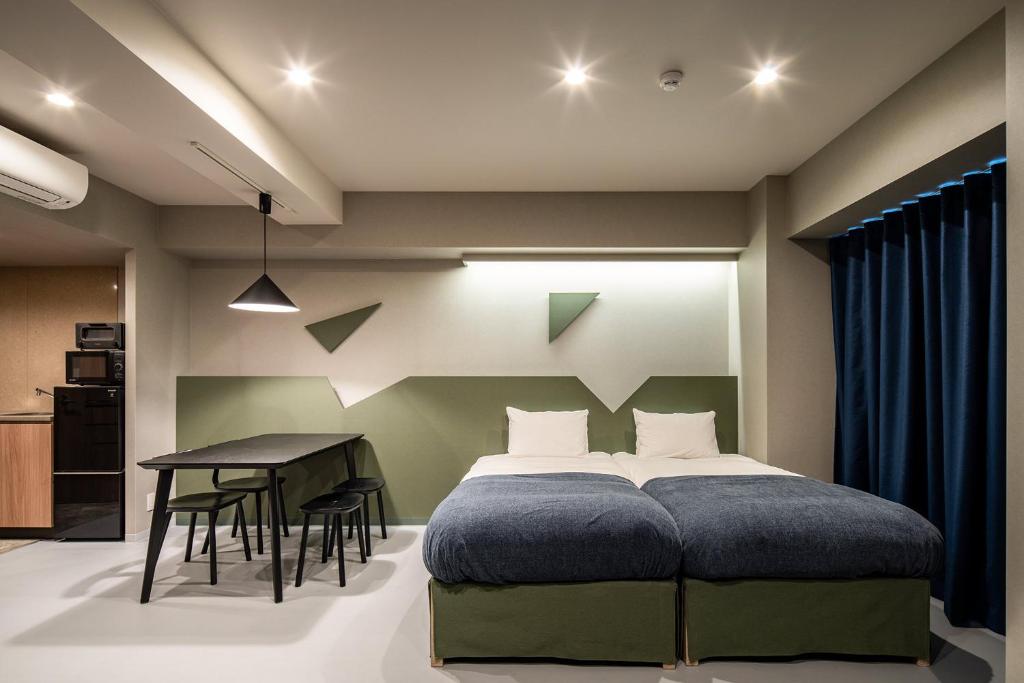 a bedroom with a bed and a table at Section L Kuramae - Asakusa in Tokyo
