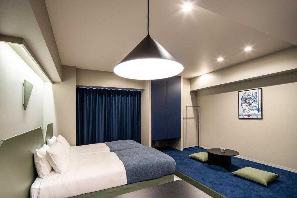 1 dormitorio con cama blanca y alfombra azul en Section L Kuramae - Asakusa en Tokio