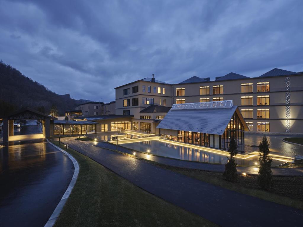 a building with a swimming pool at night at Lake Toya Tsuruga Resort HIKARINOUTA in Lake Toya