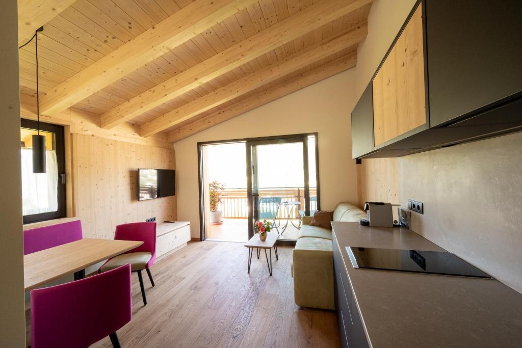 cocina y sala de estar con mesa y sillas en Sunnegg en Bressanone