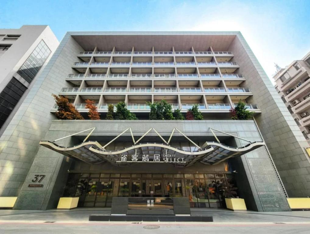 a large building with a sign on the front of it at CHECK inn SELECT Taichung Dadun in Taichung