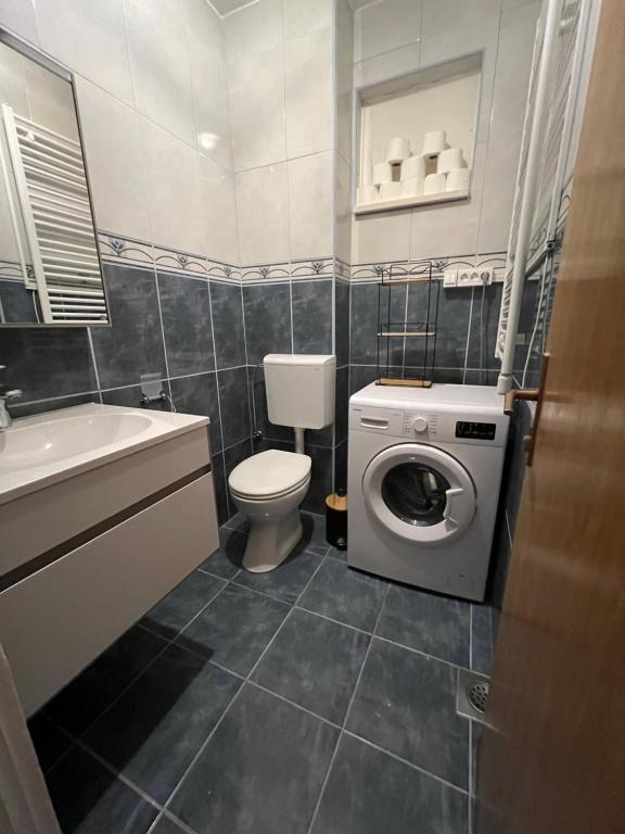 a bathroom with a toilet and a washing machine at Apartman Vera in Brela