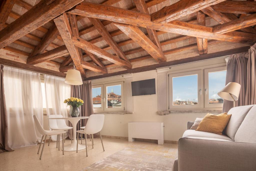 salon z drewnianym sufitem, stołem i krzesłami w obiekcie Lion Palace - San Marco R&R w Wenecji
