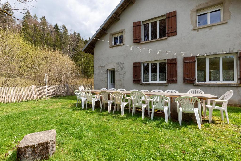 a group of tables and chairs in front of a house at Gite Du Dombief in La Chaux-du-Dombief