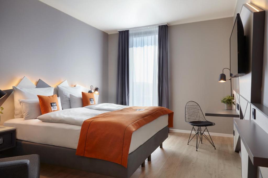 una camera d'albergo con letto e TV di the niu Hub a Dusseldorf