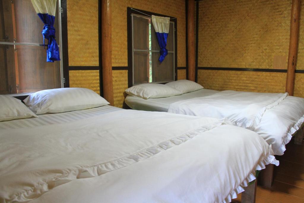 two beds with white sheets in a room at Rangbondoi - Birdwatching Included 