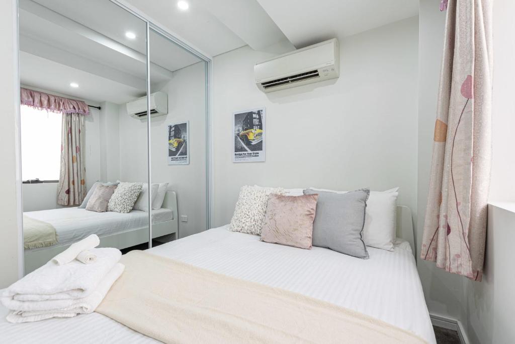 a small bedroom with two beds and a mirror at 2 BD Apt with Large Courtyard near The Star Casino in Sydney