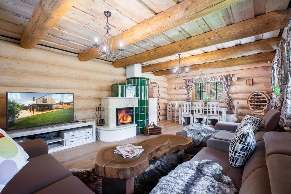 a living room with a couch and a fireplace at Chalet Durik Bystra-Jacuzzi-Sauna-Kids playground-Fire pit-Hiking in Horná Lehota