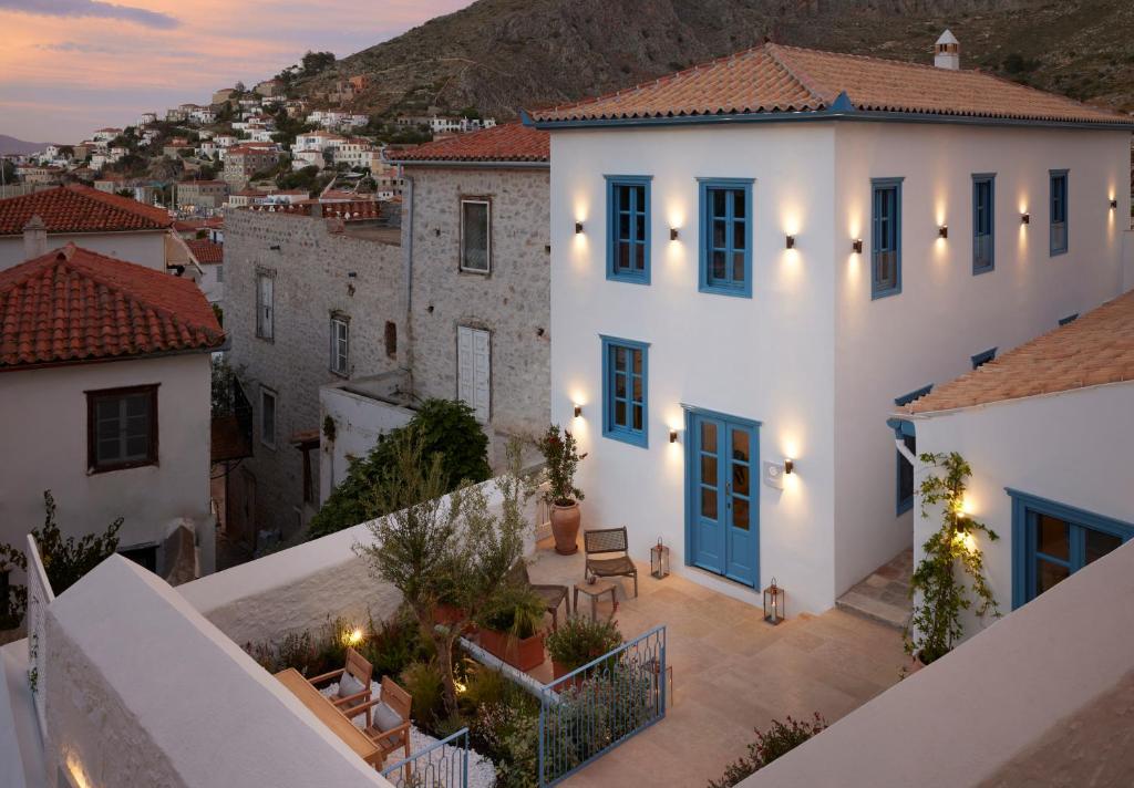 una vista de una villa en Positano al atardecer en Orloff Legacy Suites Hydra, en Hydra