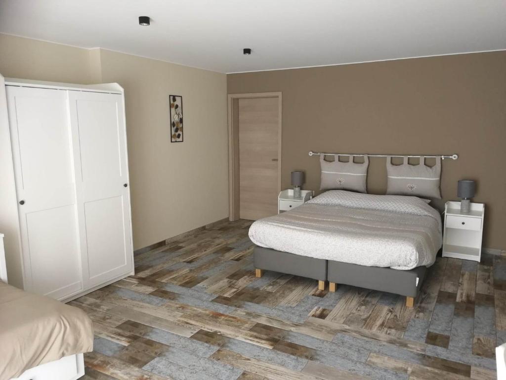 a bedroom with a bed and a wooden floor at Les chambres de la fontaine de brul in Sainte-Ode