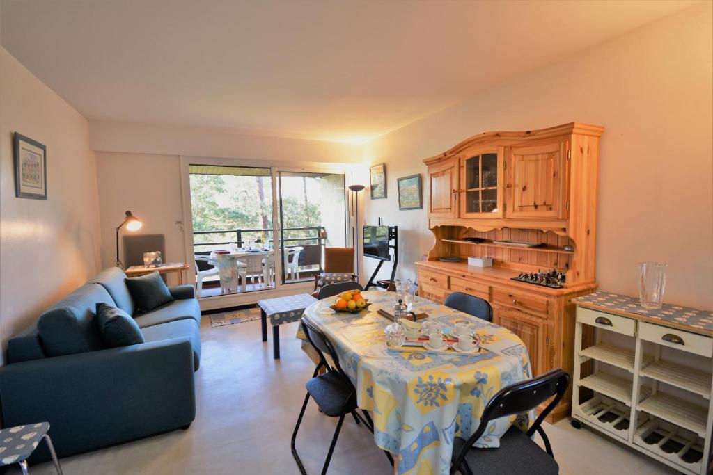 un salon avec une table et un canapé dans l'établissement Chalosse - Seignosse - Agréable appartement tout proche de l'océan, à Seignosse