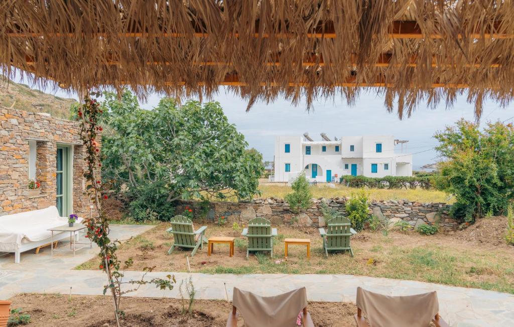 a patio with chairs and a table and a building at Houses at Chrisopigi Sifnos in Chrisopigi