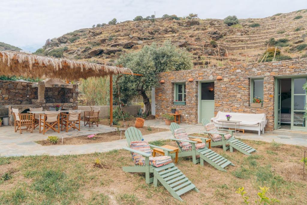 a patio with chairs and tables and a building at Houses at Chrisopigi Sifnos in Chrisopigi