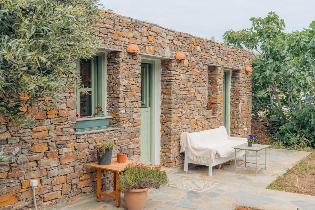 a stone building with a chair and a table at Houses at Chrisopigi Sifnos in Chrisopigi