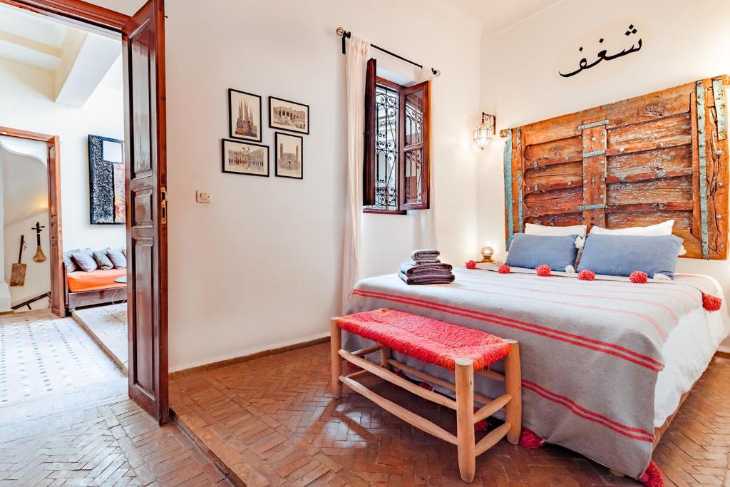 ein Schlafzimmer mit einem großen Bett und einem roten Stuhl in der Unterkunft Color Safrà in Marrakesch