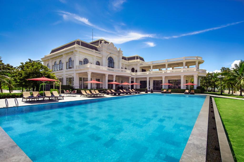 une grande maison avec une piscine en face de celle-ci dans l'établissement Paradise Suites Hotel, à Hạ Long