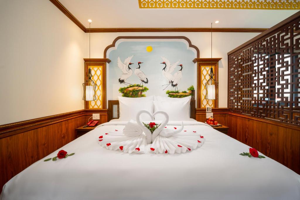 Postel nebo postele na pokoji v ubytování Hoi An Babylon Riverside Hotel & Spa